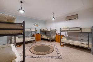 a room with three bunk beds and a rug at Hostel Nena Semi in Tirana