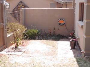 einen Innenhof eines Hauses mit einem Zaun in der Unterkunft The Cottage in Krugersdorp