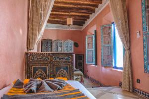 a bedroom with a bed in a room with orange walls at Héritage Lalla Aicha Hotel & Spa in Marrakesh