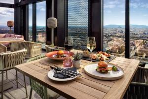 uma mesa de madeira com comida e copos de vinho em Melia Vienna em Viena