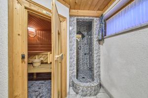 Baño con ducha a ras de suelo junto a una puerta en Landhaus Eichenhof, en Saalbach Hinterglemm