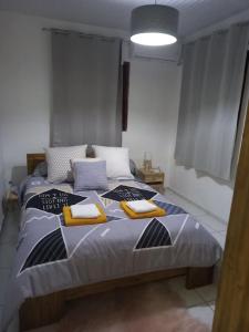 ein Schlafzimmer mit einem großen Bett mit gelben Kissen in der Unterkunft Bungalow Abricot in Petit-Bourg