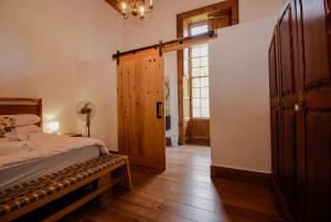 Heins Manor House في ستيلينبوش: غرفة نوم بسرير وباب خشبي