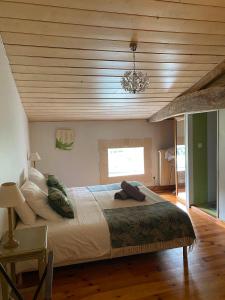 sypialnia z dużym łóżkiem i drewnianym sufitem w obiekcie Maison d'Emmannaelle w mieście Auros
