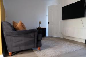 a living room with a chair and a flat screen tv at Cosy Chester home - 0.6 miles from the centre in Chester