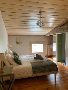 1 dormitorio con 1 cama grande y techo de madera en Maison d'Emmannaelle en Auros