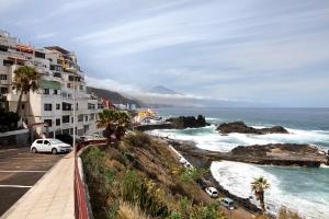 - une vue sur l'océan avec ses bâtiments et ses voitures dans l'établissement Casita acogedora frente al mar, à El Pris