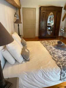 1 dormitorio con 1 cama grande con almohadas blancas en Maison d'Emmannaelle en Auros
