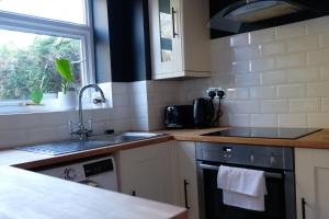 a kitchen with a sink and a stove at Cosy Chester home - 0.6 miles from the centre in Chester
