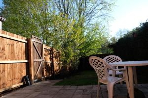 a patio with a table and chairs and a fence at Cosy Chester home - 0.6 miles from the centre in Chester