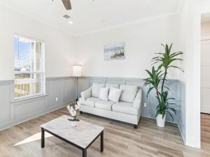 a living room with a white couch and a table at Sandy Smiles in Galveston