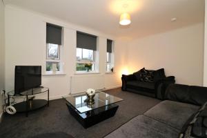 a living room with a couch and a tv at Signature - Carrick View in Cumbernauld