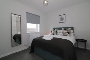 a bedroom with a bed and a mirror at Signature - Caldercruix House in Caldercruix
