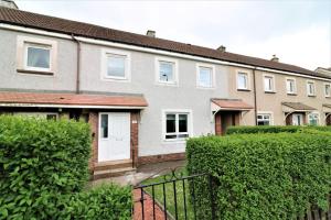 a row of houses with bushes in front of them at Signature - Caldercruix House in Caldercruix