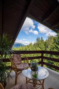 a patio with a glass table and chairs on a balcony at Love Luxury studio in Predeal