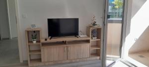 a flat screen tv sitting on a wooden entertainment center at Coresi KASPERS Camil Petrescu, 2 camere apartment, sleeps 6 in Braşov