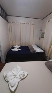 Un dormitorio con una cama con toallas blancas. en Dion's Place, en Iloilo City