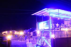 a building with lights on it at night at Chanaka Eco Camp ( Adventure Assam ) in Pakariāmukh
