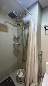 La salle de bains est pourvue d'un rideau de douche et de toilettes. dans l'établissement Your Home@MOA*Airports*Jacuzzi*FastWiFi*Netflix, à Manille