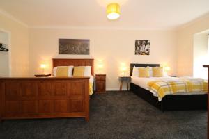 a bedroom with two beds and two night stands at Signature - Kirkhill House in Kirkmuirhill