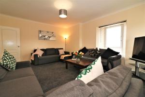 a living room with two couches and a television at Signature - Kirkhill House in Kirkmuirhill