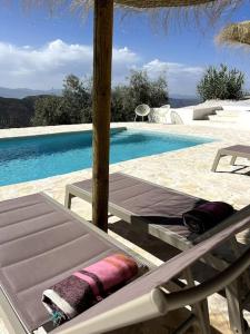 una piscina con una mesa y una silla junto a una piscina en Casa Juncares, en Iznájar