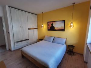 a bedroom with a bed and a yellow wall at Appartamento di design sull'Altopiano di Asiago in Tresché Conca