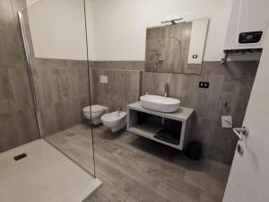 a bathroom with a sink and a toilet and a shower at Appartamento di design sull'Altopiano di Asiago in Tresché Conca