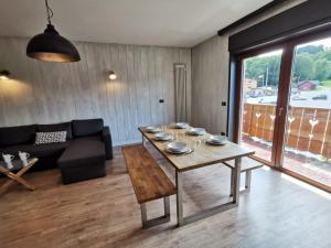 sala de estar con mesa y sofá en Appartamento di design sull'Altopiano di Asiago en Tresché Conca