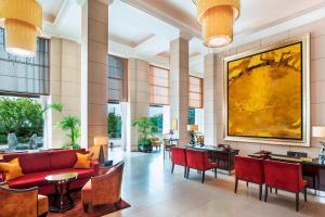 a lobby with red furniture and a large painting on the wall at St. Regis Osaka in Osaka