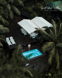an overhead view of a man standing next to a swimming pool at South Point Villas Cerf Island in Cerf Island