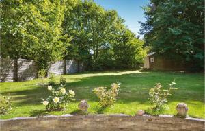 ジルレジェにあるBeautiful Home In Gilleleje With 2 Bedrooms And Wifiの塀と木の庭のある裏庭