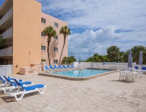 a swimming pool with lounge chairs and a hotel at Beach Tennis 217 in Coquina Gables