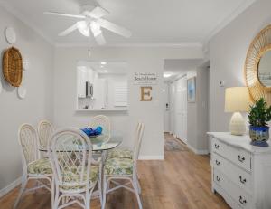 a kitchen and dining room with a table and chairs at Beach Tennis 217 in Coquina Gables