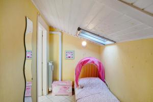 a room with a bed with a pink cover at Ca' a riga in Diano Castello