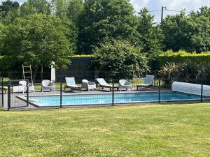 a fence with chairs and a pool in a yard at Tente Lodge Calme, Nature, Piscine in Clohars-Fouesnant