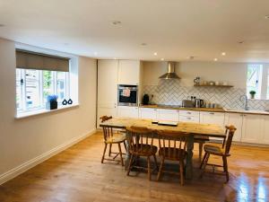 a kitchen with a large wooden table and chairs at The Cottage in Birdbrook