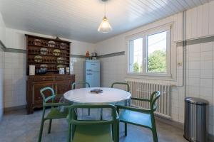 uma cozinha com uma mesa e cadeiras e um frigorífico em Maison Névez Campagne Calme Piscine em Clohars-Fouesnant