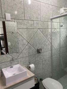 uma casa de banho com um lavatório e um WC em Suites da Rota - Pomerode SC em Pomerode