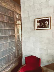 une chaise rouge dans une chambre avec un mur en briques dans l'établissement Harry Potter expérience, à Marseille