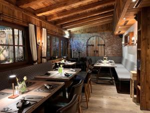 a restaurant with wooden ceilings and tables and chairs at Hotel Alexander in Kirchberg in Tirol