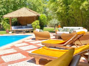 a patio with chairs and a gazebo next to a pool at Appart Karibu in Callian