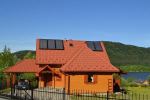 a house with solar panels on the roof at Domki Klimkówka in Klimkówka