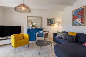 - un salon avec un canapé et une télévision dans l'établissement Maison Coz Campagne Calme Piscine, à Clohars-Fouesnant