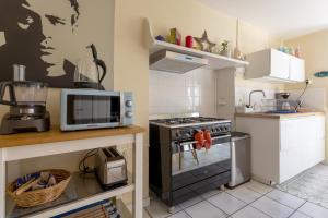 a kitchen with a stove and a microwave at Maison Coz Campagne Calme Piscine in Clohars-Fouesnant