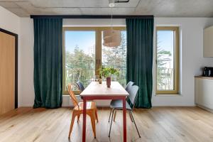 a dining room with green curtains and a table with chairs at T8- Willa Tetmajera Gdynia in Gdynia