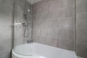 a bathroom with a shower and a tub and a toilet at Signature - Culzean House in Newarthill