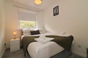 1 dormitorio con 2 camas y toallas. en Signature - Culzean House en Newarthill