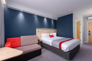 a hotel room with a bed and a couch at Holiday Inn Express Ramsgate – Minster by IHG in Minster