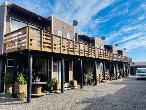 um edifício com varandas e um carro estacionado em frente em ELUNEY Pichilemu em Pichilemu